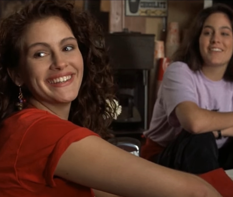 alt="Julia Roberts sits at a pizza parlor in Mystic Pizza"
