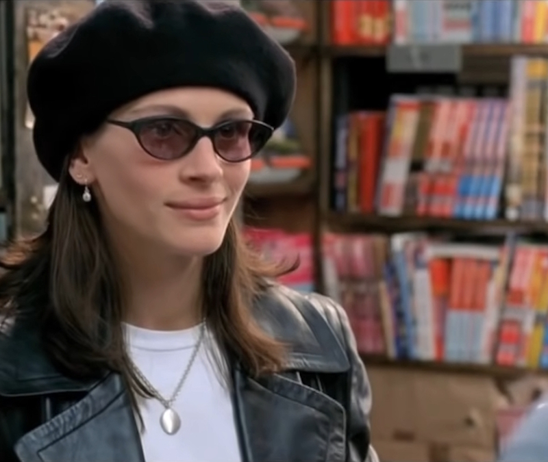 alt="Julia Roberts stands smiling in a book store in Notting Hill"