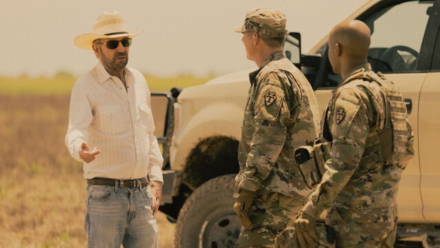 alt="Billy Bob Thornton as Tommy Norris speaking with military officers in West Texas in Landman on Paramount+."